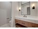 Modern bathroom with a white marble countertop, wood cabinets, and wall sconces at 6075 Dapple Gray Rd, Las Vegas, NV 89149