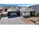 Modern single-story home with a desert landscape, paved driveway, and views of the neighborhood at 6075 Dapple Gray Rd, Las Vegas, NV 89149