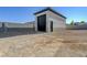 View of the exterior of a detached garage next to a vacant space at 6075 Dapple Gray Rd, Las Vegas, NV 89149