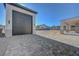 View of a detached garage next to a covered patio and a large empty space at 6075 Dapple Gray Rd, Las Vegas, NV 89149