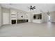 Spacious living room with modern fireplace, fan, built in shelving and wet bar with open floor plan at 6075 Dapple Gray Rd, Las Vegas, NV 89149