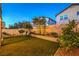 Backyard featuring artificial turf, lounge chairs, brick retaining wall, and desert landscaping at 6546 American Flower St, Las Vegas, NV 89148