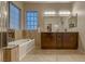 Bathroom featuring a tub, granite countertops, and soft, ambient lighting at 672 Solitude Point Ave, Henderson, NV 89012
