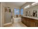 Luxurious bathroom features a glass shower, large tub, dual sink vanity and modern lighting at 672 Solitude Point Ave, Henderson, NV 89012