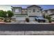 Street view of a two-story stucco home featuring a two-car garage and tidy landscaping at 672 Solitude Point Ave, Henderson, NV 89012