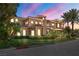 Beautiful two-story home with a lush green lawn and mature palm trees at 7 Rue Promenade Way, Henderson, NV 89011