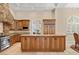 Gourmet kitchen featuring custom cabinets, granite countertops, stainless steel appliances, and a large central island at 7 Rue Promenade Way, Henderson, NV 89011