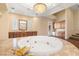 Bright bathroom features a jacuzzi tub, custom cabinets, a mini fridge, and hardwood floors at 7 Rue Promenade Way, Henderson, NV 89011