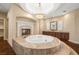 Main bathroom features a jacuzzi tub with marble surround, fireplace, custom cabinetry, and hardwood floors at 7 Rue Promenade Way, Henderson, NV 89011