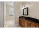 Well-lit powder room showcasing cabinet with stone countertop and framed mirror at 7 Rue Promenade Way, Henderson, NV 89011