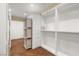 Spacious walk-in closet featuring custom shelving, built-in drawers, and hardwood floors at 7 Rue Promenade Way, Henderson, NV 89011