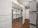 Bright walk-in closet with custom shelving, mirrored wall, drawers and rich wood flooring at 7 Rue Promenade Way, Henderson, NV 89011