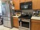 Modern kitchen with stainless steel appliances, wooden cabinets, and gas range at 728 Brown Breeches Ave, North Las Vegas, NV 89081