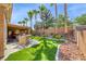 Backyard showcasing outdoor kitchen area with a covered patio, lush green lawn, and mature trees at 7311 Chaparral Cove Ln, Las Vegas, NV 89131