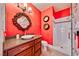 This vibrant bathroom has red walls, dark wood vanity, vessel sink, and walk-in shower at 7311 Chaparral Cove Ln, Las Vegas, NV 89131