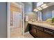 En suite bathroom featuring a dark wood vanity with marble top, modern fixtures, and access to a separate toilet at 7311 Chaparral Cove Ln, Las Vegas, NV 89131
