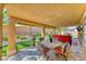 Spacious covered patio with stone flooring, outdoor dining area, and backyard views, perfect for entertaining at 7311 Chaparral Cove Ln, Las Vegas, NV 89131