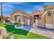 Close-up of the front entrance with lush green landscaping, pavers, and stylish gate at 7311 Chaparral Cove Ln, Las Vegas, NV 89131
