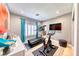 Bright home gym with hardwood floors, workout equipment, flat screen television, and vibrant decor at 7311 Chaparral Cove Ln, Las Vegas, NV 89131