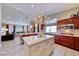Open kitchen and living room area, stainless appliances, cherry wood cabinets, and modern light fixture at 7311 Chaparral Cove Ln, Las Vegas, NV 89131