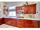 Close up of a kitchen with stainless steel appliances, cherry wood cabinets, and tile backsplash at 7311 Chaparral Cove Ln, Las Vegas, NV 89131