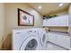 Well-organized laundry room with front loading Samsung washer/dryer, cabinetry, and ample counter space at 7311 Chaparral Cove Ln, Las Vegas, NV 89131