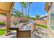 Outdoor kitchen area with custom counter, built in grill, lush landscaping, and stone patio at 7311 Chaparral Cove Ln, Las Vegas, NV 89131