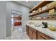 Walk-in pantry with custom shelves, granite countertops, and cherry wood cabinets at 7311 Chaparral Cove Ln, Las Vegas, NV 89131