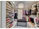 Spacious walk-in closet with custom shelving, drawers and mirrored ottoman storage and a modern chandelier at 7311 Chaparral Cove Ln, Las Vegas, NV 89131