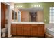 Bathroom with a double vanity and large mirror with lights at 7340 Elderly Ave, Las Vegas, NV 89131