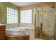 Bathroom featuring a soaking tub, glass shower, and block window at 7340 Elderly Ave, Las Vegas, NV 89131