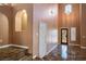 Inviting foyer showcasing soaring ceilings, tile flooring, a decorative front door, and a staircase at 7340 Elderly Ave, Las Vegas, NV 89131