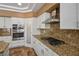 Bright kitchen with granite countertops, stainless steel appliances, and custom white cabinetry at 7340 Elderly Ave, Las Vegas, NV 89131
