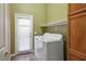 Bright laundry room featuring white washer and dryer, storage, shelving, and exterior access at 7340 Elderly Ave, Las Vegas, NV 89131