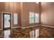 Bright and airy living room with a decorative front door, tile flooring, and plantation shutters for added privacy at 7340 Elderly Ave, Las Vegas, NV 89131