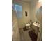 Bright powder room with pedestal sink, oval mirror and wood-look tile flooring at 777 Star Apple Ln, Las Vegas, NV 89178