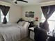 Cozy bedroom featuring a ceiling fan, window, desk, and comfortable bed at 777 Star Apple Ln, Las Vegas, NV 89178