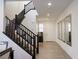 Bright entryway features a staircase with black railings, wood-look tile flooring, and large decorative mirrors at 777 Star Apple Ln, Las Vegas, NV 89178