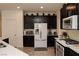 Well-equipped kitchen with dark cabinets, stainless steel appliances, and a bright white refrigerator at 777 Star Apple Ln, Las Vegas, NV 89178