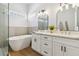 Stylish bathroom with double vanity, elegant mirrors, and a luxurious soaking tub at 8312 Raphael Ct, Las Vegas, NV 89129