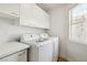 Bright laundry room with modern washer, dryer, countertop and ample cabinet space at 8312 Raphael Ct, Las Vegas, NV 89129