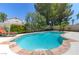 Inviting backyard pool featuring a stone trim, lush landscaping and a lounge area at 8312 Raphael Ct, Las Vegas, NV 89129