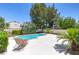 A beautiful backyard pool with a lounge area surrounded by mature landscaping and privacy walls at 8312 Raphael Ct, Las Vegas, NV 89129