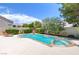 Inviting backyard pool featuring a stone trim, lush landscaping and a lounge area at 8312 Raphael Ct, Las Vegas, NV 89129