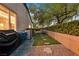 Backyard features a small artificial turf area with lounge chairs, desert landscaping, and a privacy wall at 8370 Plum Creek Ct, Las Vegas, NV 89113