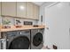 Laundry room featuring washer and dryer units, storage cabinets, and wooden countertops at 8370 Plum Creek Ct, Las Vegas, NV 89113