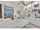 Bright office featuring built-in bookshelves, modern white desk, and an open floor plan into the living area at 8370 Plum Creek Ct, Las Vegas, NV 89113