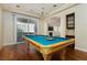 Game room with a billiards table, chandelier, and sliding glass doors leading to a patio area at 8467 Bismark Sapphire St, Las Vegas, NV 89139