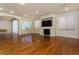 Open living room with hardwood floors, a fireplace, built-in shelving, and large windows for natural light at 8467 Bismark Sapphire St, Las Vegas, NV 89139
