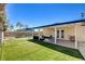 The backyard has a covered patio, lush lawn, and privacy fencing at 925 Alan Shepard St, Las Vegas, NV 89145